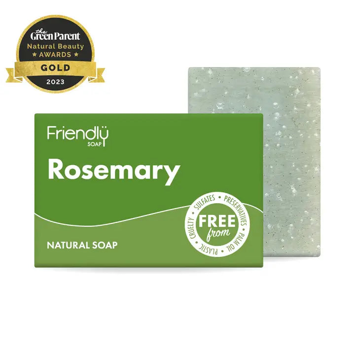Friendly Soap Rosemary Soap Bar stood vertically slightly behind and to the left of a green cardboard box with Friendly Soap branding and Rosemary written in white. The soap and box are on a white background