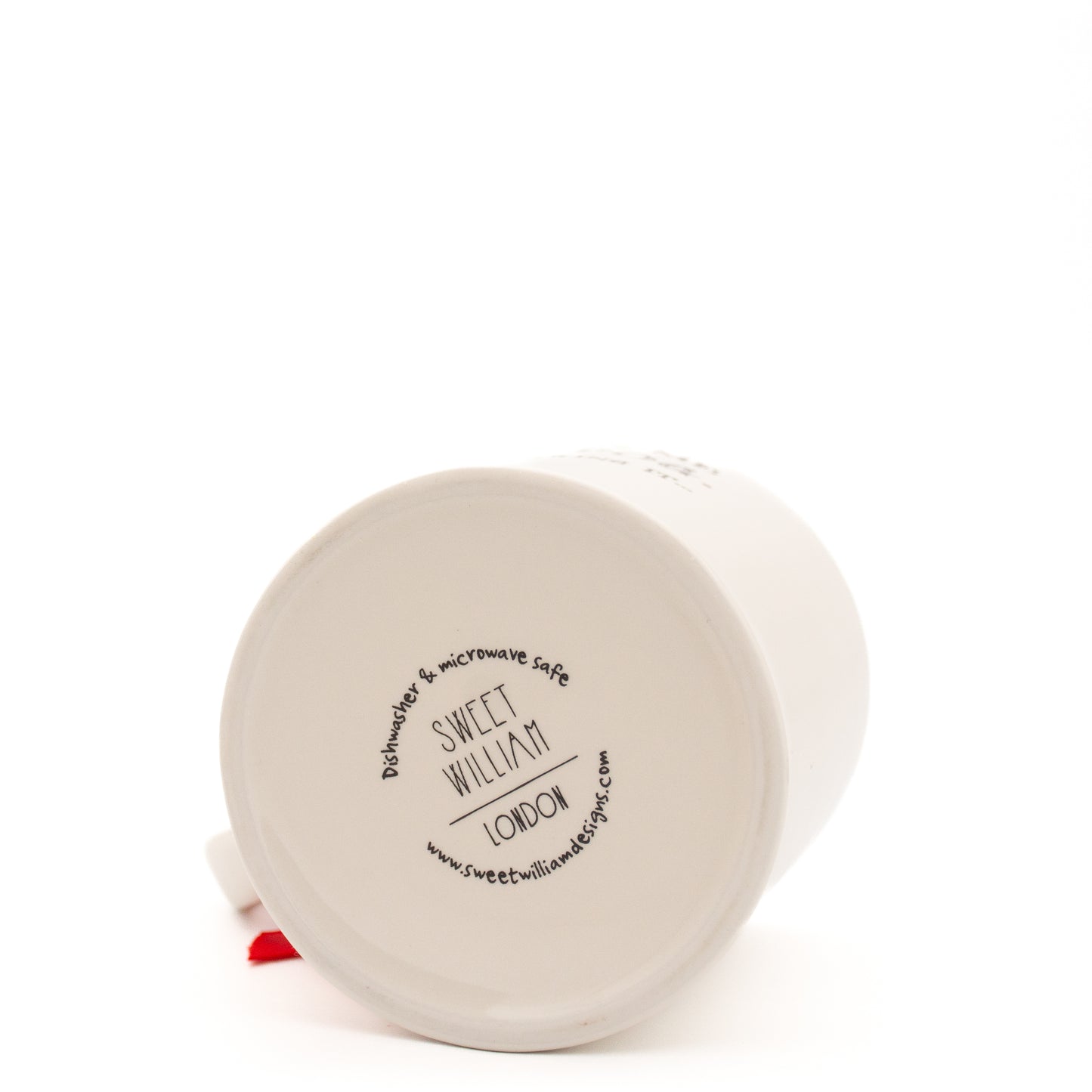 A white Sweet William mug, lying on its side with the base facing the camera. The base shows Sweet William London in black, with the website address and information about the mug being microwave and dishwasher safe in a circle around the brand name. The mug is shown on a white background.