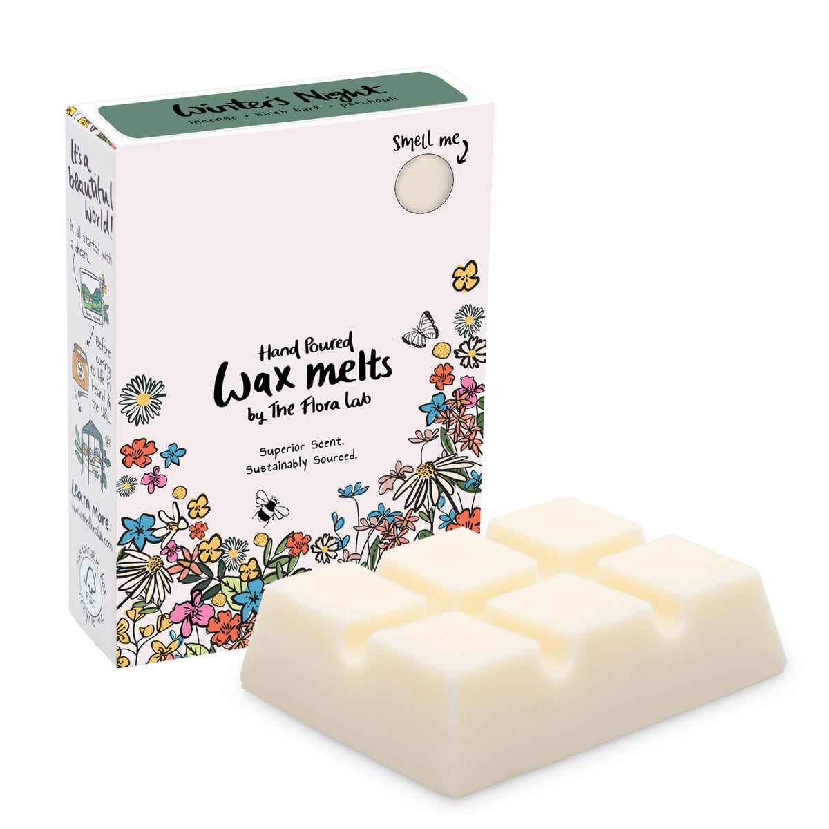 The Flora Lab Winter’s Night scented wax melt box with a dark green top and floral decorations on the bottom front edge stood in front of a white slab of wax melts. They are placed on a white background