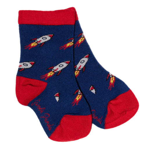 Swole Panda children socks with a rocket pattern. The rockets are silver with a red nose and fins. The rockets also have yellow and red flames coming out of the bottom. The socks have bright red toes, heels and cuffs, and the main body of the socks are navy blue. The pair is sat on a white background.