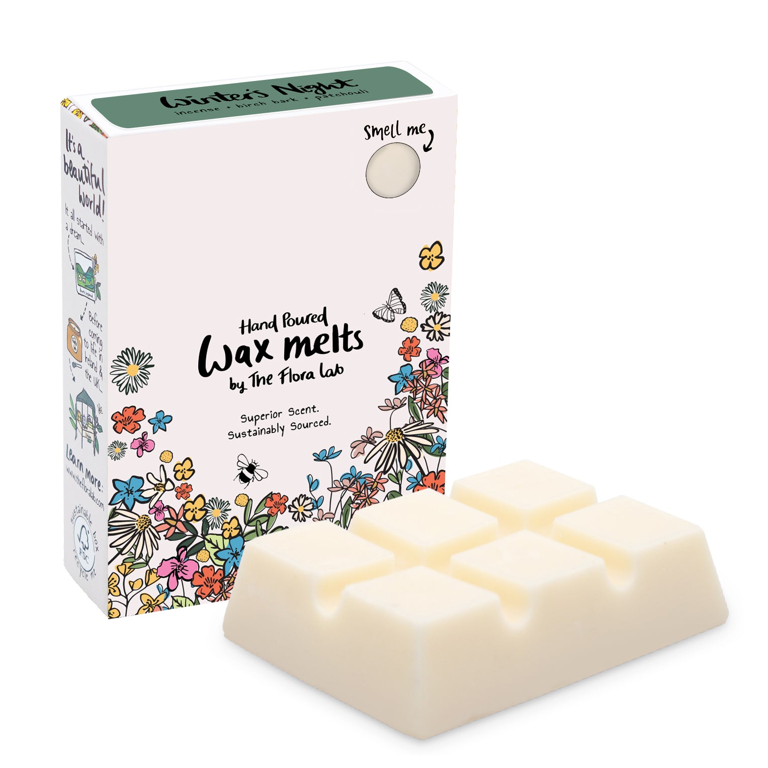 The Flora Lab Winter’s Night scented wax melt box with a dark green top and floral decorations on the bottom front edge stood in front of a white slab of wax melts. They are placed on a white background