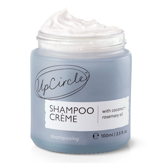 Blue jar of UpCircle Shampoo Crème with Coconut and Rosemary Oil. The shampoo Crème is whipped out the top of the jar, on a white background.